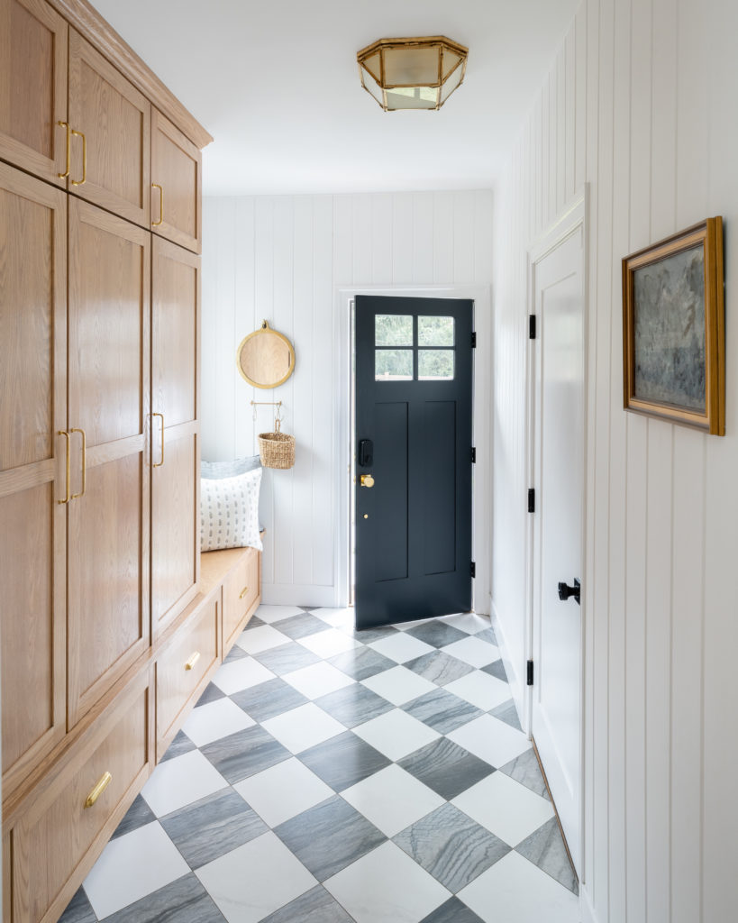 Interior designer photoshoot featuring a modern and classic mudroom with checkerboard marble tile and custom cabinetry.