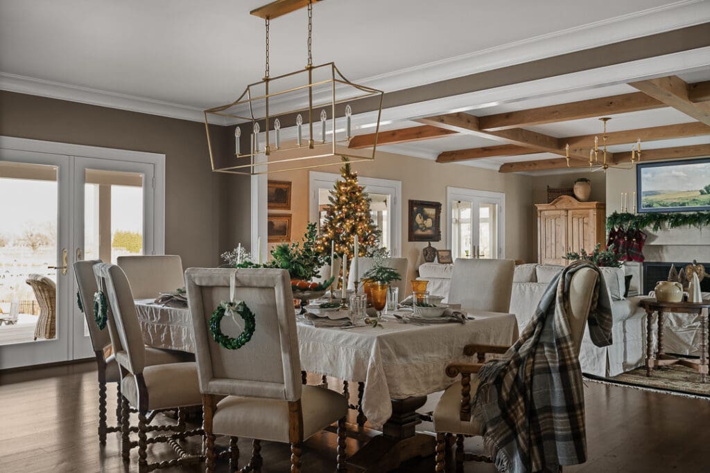 Dining room with mismatched tartan, heirloom silver collection, and Ralph Lauren–inspired holiday décor, styled by Ginny Padula and photographed with soft directional lighting.